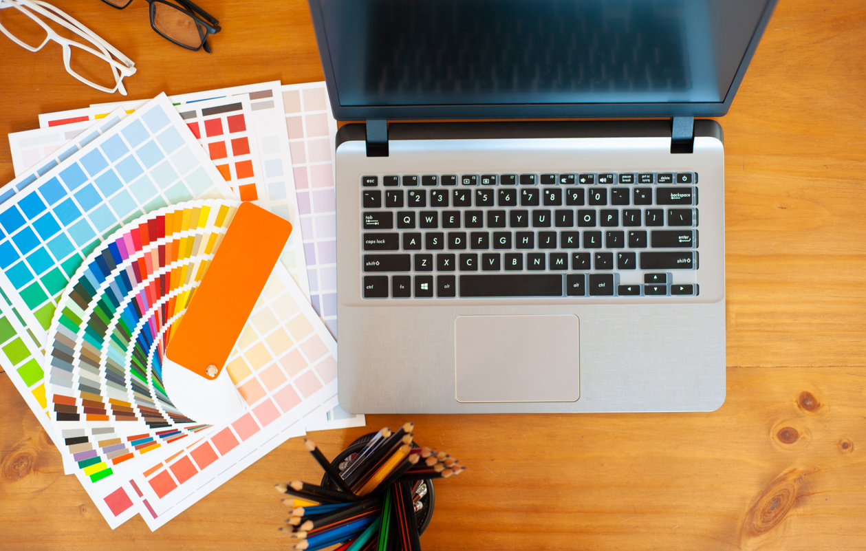 Graphic designer desk. Graphic designer laptop and color swatch examples.